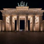 Berlin: City tour at night with illuminated sights - Visiting the Brandenburg Gate in Warm Nighttime Light