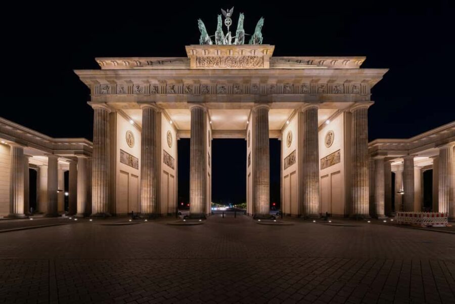 Berlin: City tour at night with illuminated sights - Visiting the Brandenburg Gate in Warm Nighttime Light