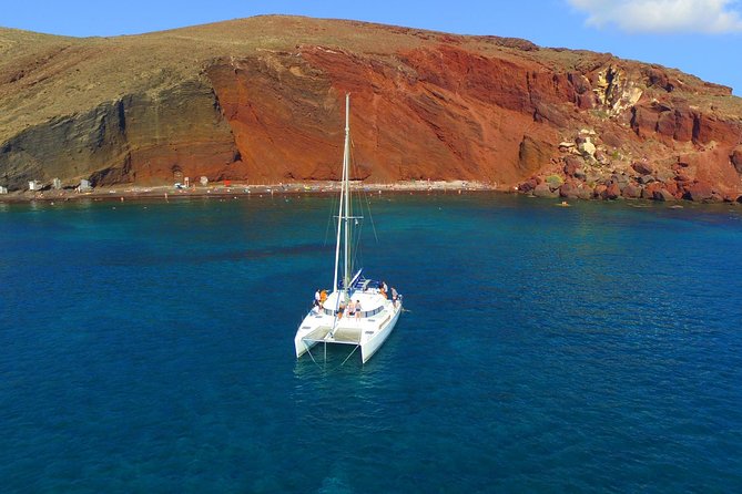 Santorini Full Day Catamaran Private Cruise incl. Meal, Drinks & Free Transport - Exploring the Red Beach’s Unique Volcanic Landscape