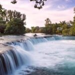 Side: Guided Tour and Electric Catamaran Cruise, Waterfall - Scenic Waterfalls and Lush Orange Groves Near Side