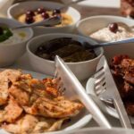 Santorini Luxury Sailing Catamaran Cruise with BBQ, Drinks and Transfer - Enjoying Greek Cuisine and Open Bar on Deck